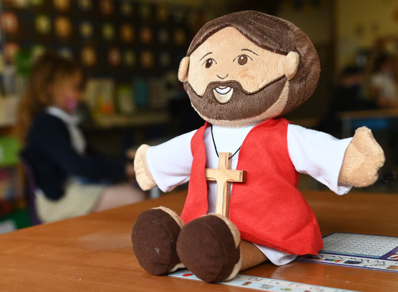 Jesus plush on classroom table.