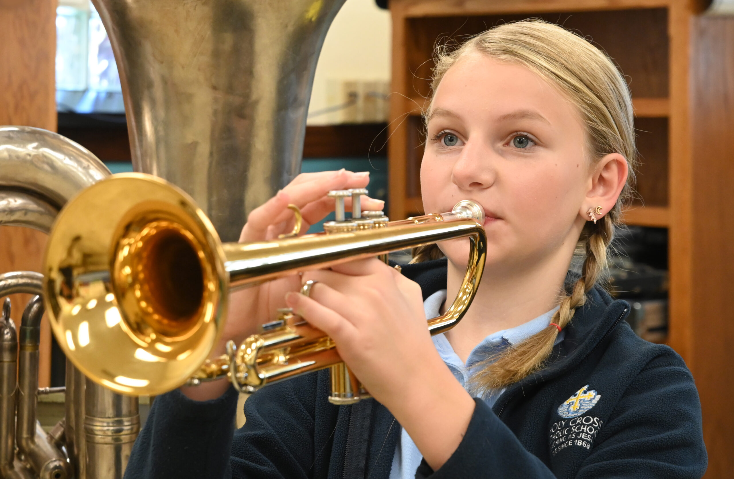 Holy Cross student plays trumpet in band class.