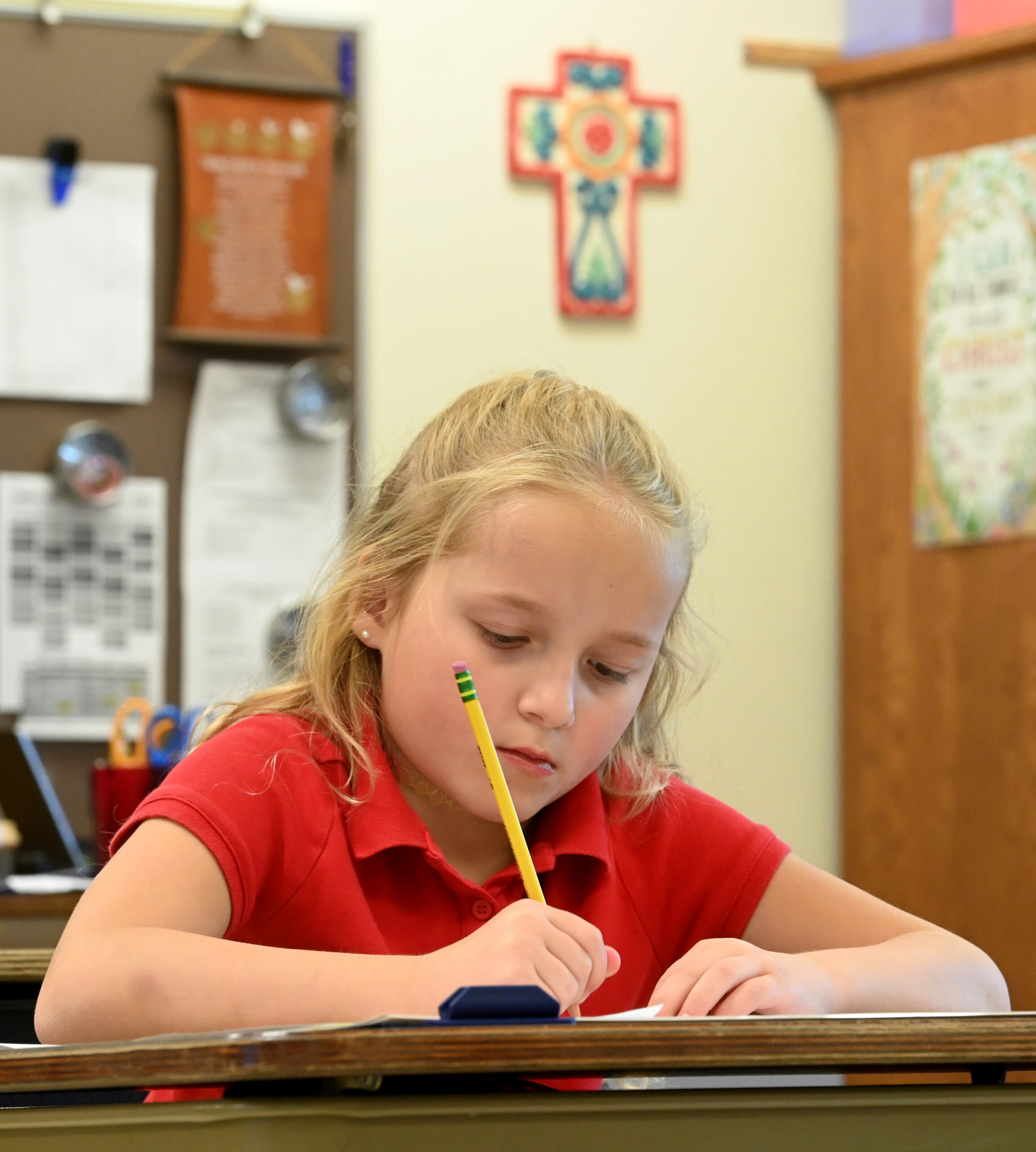 Student writes during class at Holy Cross School which is located near the Red Smith neighborhood.